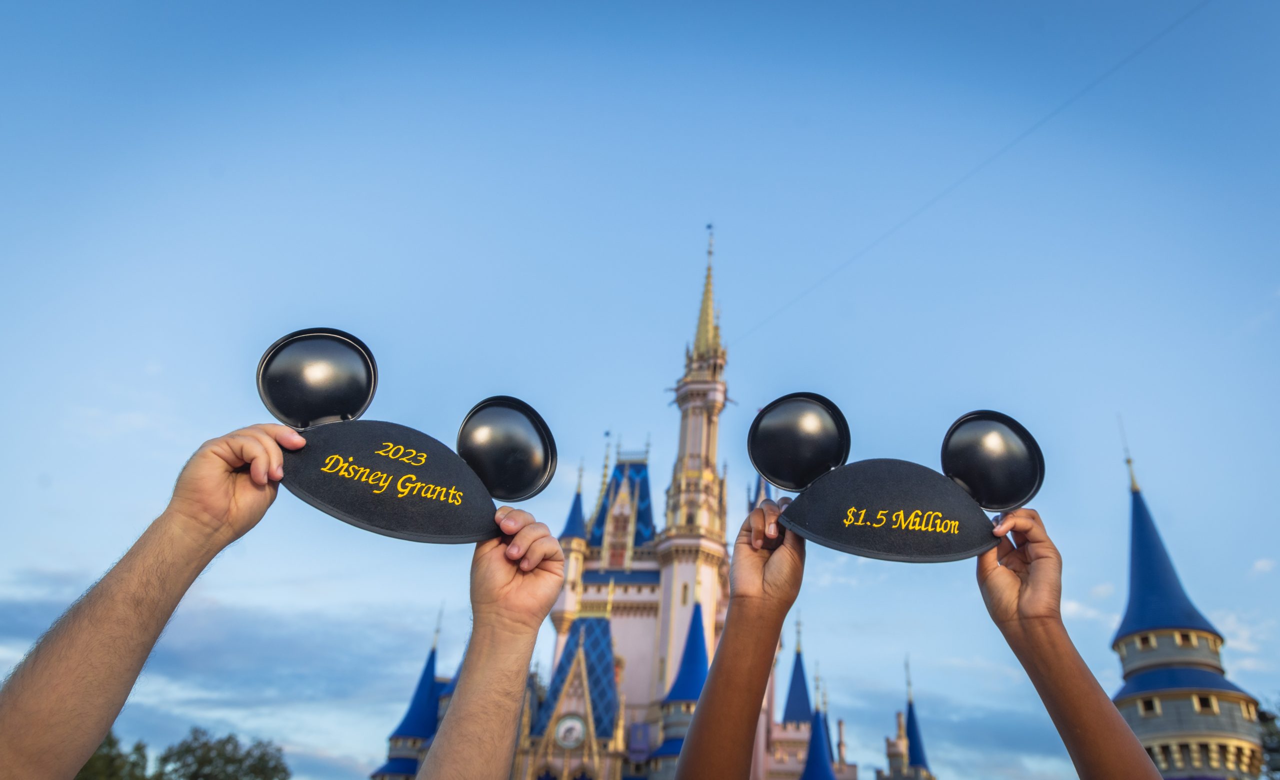 Two Mickey ear hats in front of Cinderella Castle with the embroidery saying