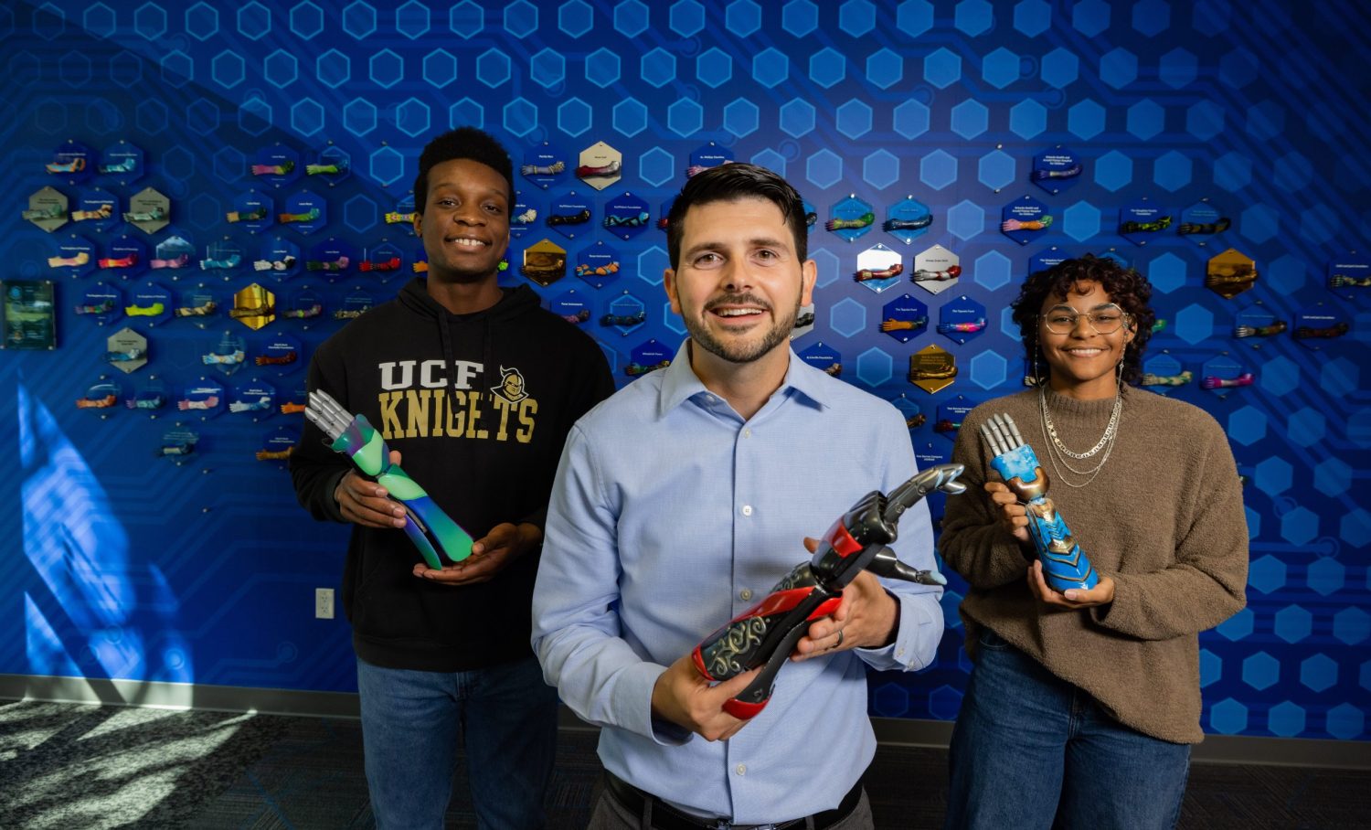 Three people holding bionic arms