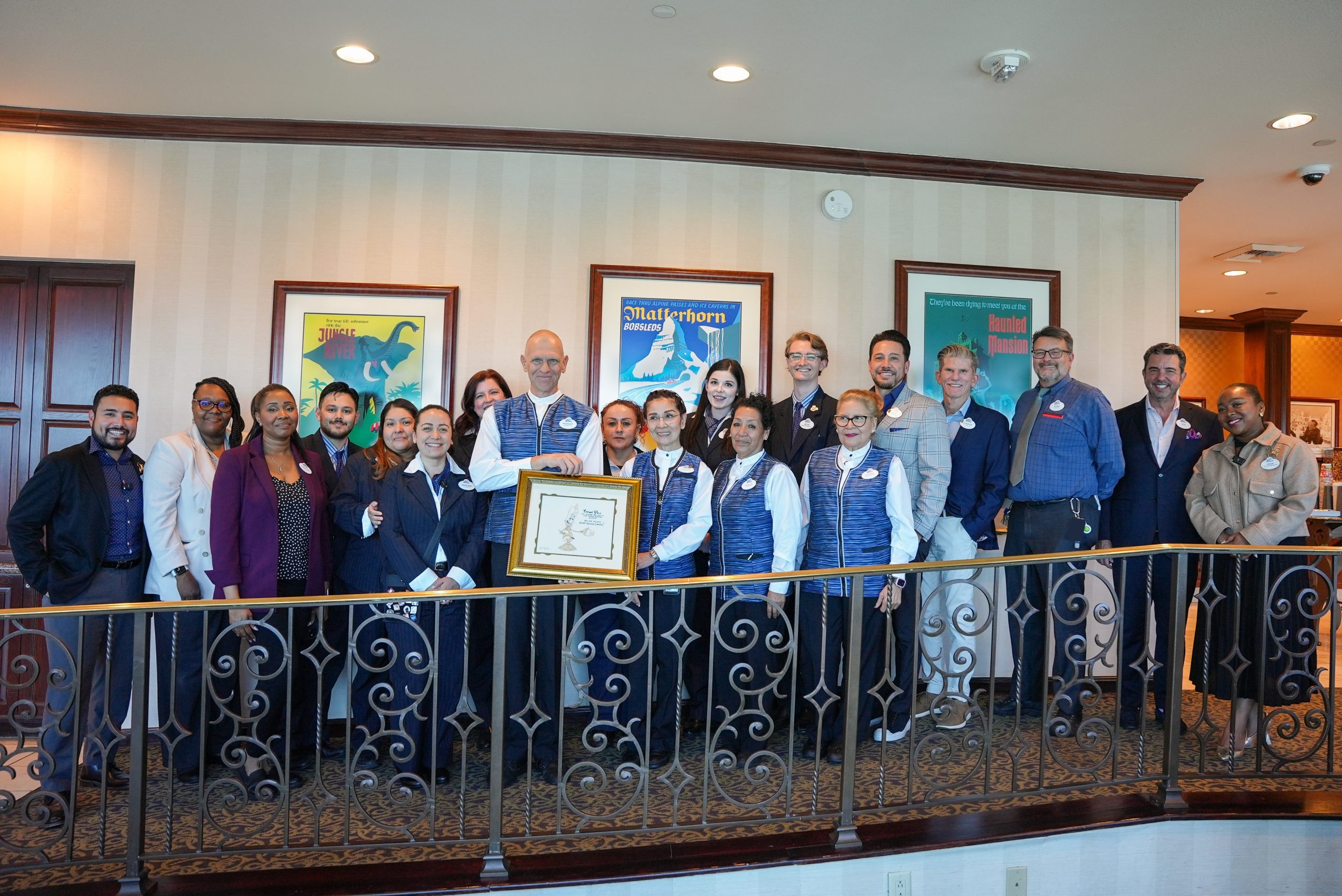 Surrounded by fellow cast members and leaders, Robert was gifted a personalized illustration celebrating him as a "Service Champion."