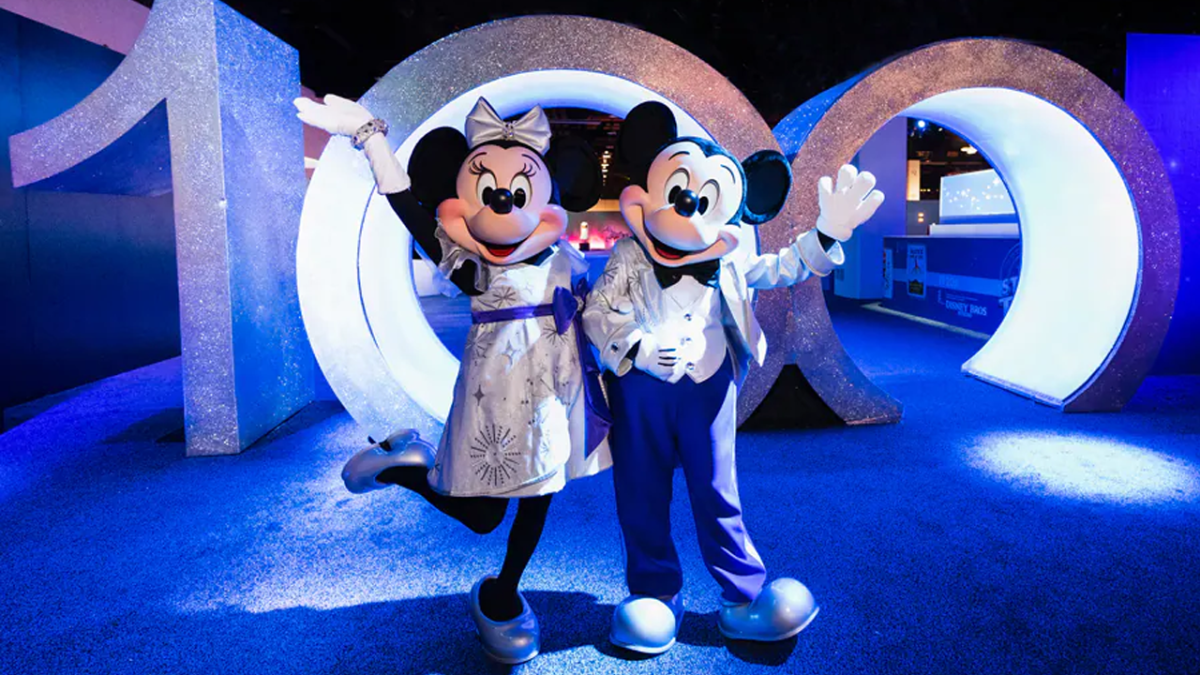 Mickey and Minnie pose with 100 numbers.