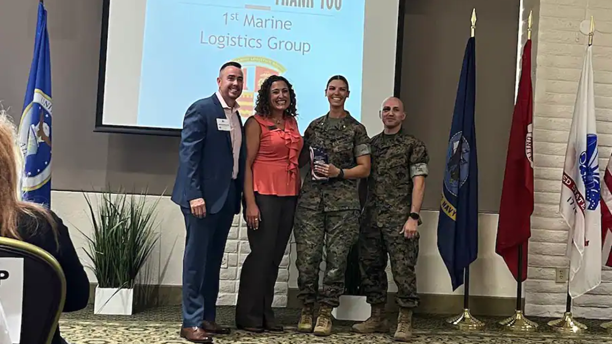 Man and women dressed in business clothes with woman and man in army uniforms.